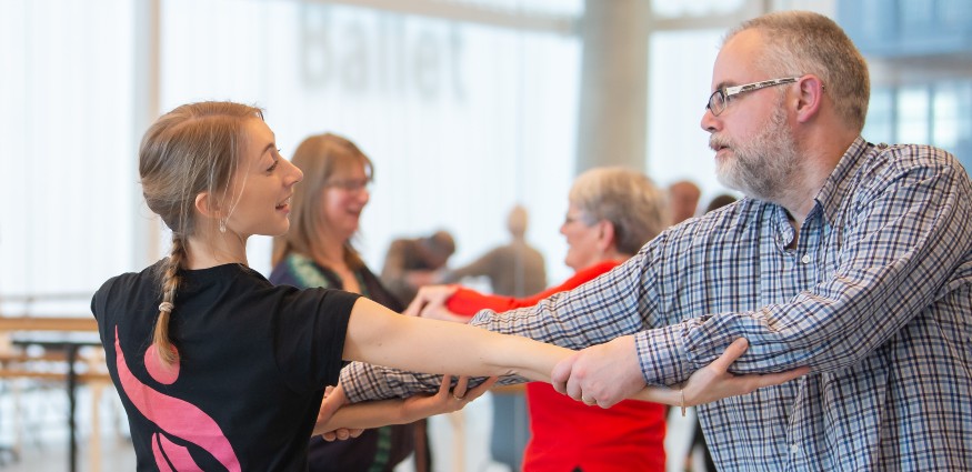 A man and woman holding hands whilst dancing.